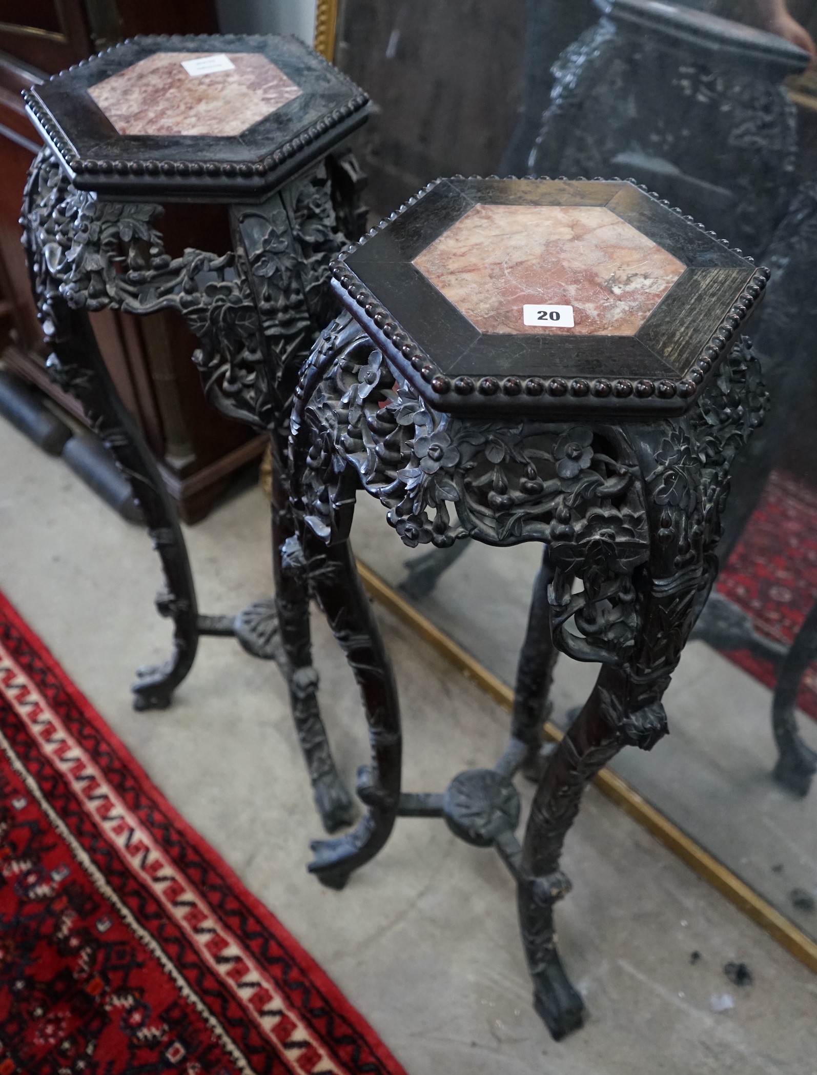 A pair of Chinese carved hardwood hexagonal marble topped vase stands, height 91cm